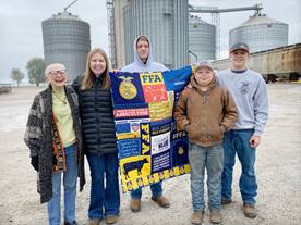 (From Left to Right) Emily Remster presents her home-made FFA quilt to Morgan Township Ag teacher and FFA advisor, Rachel Stoner, and three of her students—Logan Grieger, Tyler Banks and Lane Banks. The quilt was presented on Gift of Grain Chili Day.