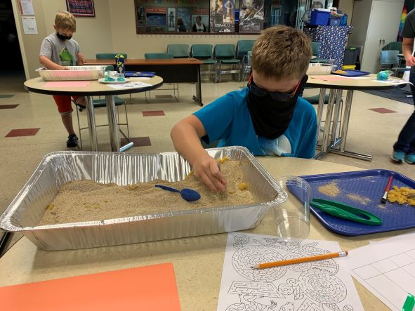 Young paleontologists unearth pasta fossils to simulate an archeological dig site at Challenger Learning Center’s summer camp